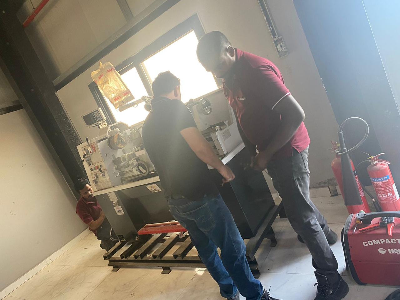 MASSAED technicians inspecting machining equipment during set-up at the factory