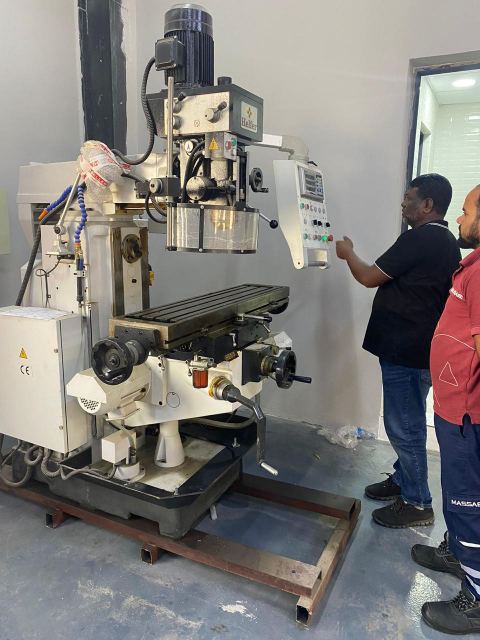 Technicians at the precision milling machine