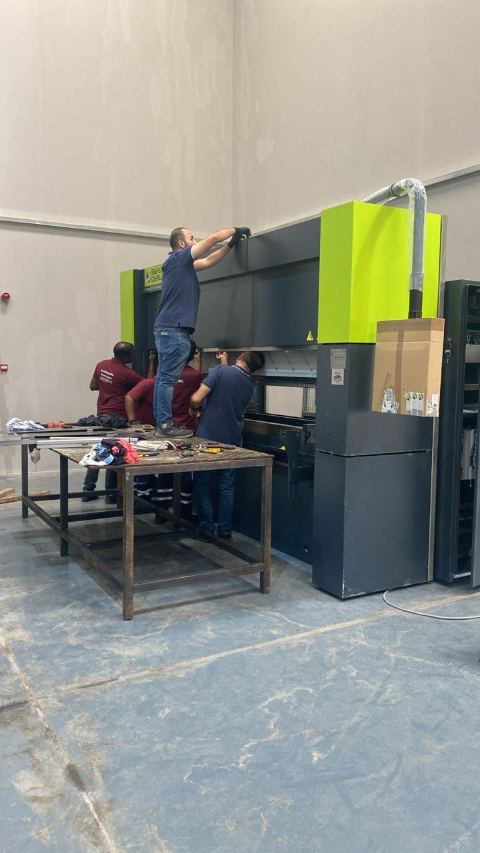 Technicians installing and aligning the CNC press brake